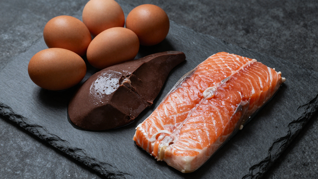 Beef liver, eggs and salmon on a dark slate board